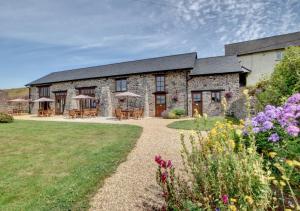 a stone building with tables and chairs in a yard at The Gearing in Bampton