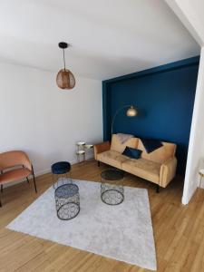 ein Wohnzimmer mit einem Sofa und 2 Stühlen in der Unterkunft Magnifique Appartement Esprit Art Déco in Romans-sur-Isère