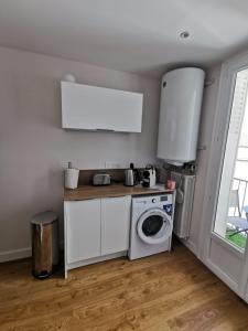 eine Küche mit einer Waschmaschine und einer Waschmaschine in der Unterkunft Magnifique Appartement Esprit Art Déco in Romans-sur-Isère