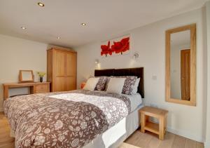 a bedroom with a large bed and a mirror at The Granary Muddiford in Shirwell