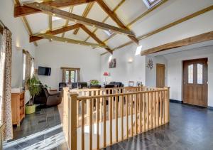 an open living room with a wooden staircase and a living room at The Granary Muddiford in Shirwell