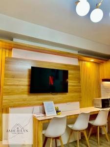 Cette chambre comprend un bureau avec des chaises et une télévision. dans l'établissement Your home away from home, at the heart of Bacolod., à Bacolod