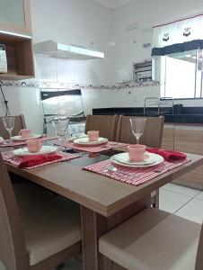 eine Küche mit einem Tisch mit Tellern und Gläsern darauf in der Unterkunft Casa Temporada BV Capitolio in Capitólio