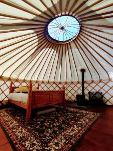 Beautiful Yurt with stunning South Downs views في Graffham: غرفة مع سرير في يورت مع نافذة