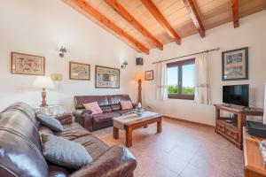 a living room with a couch and a tv at Ca Na Neus in Pollença