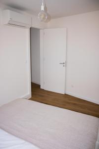 um quarto com paredes brancas e uma cama com um tapete em Apartamento Sta Maria - Sta Catarina Place em Ponta Delgada