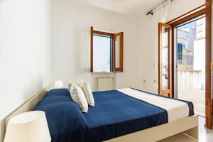 Un dormitorio con una cama con una manta azul. en Appartamento Il Belvedere - MyHo Casa, en Vieste