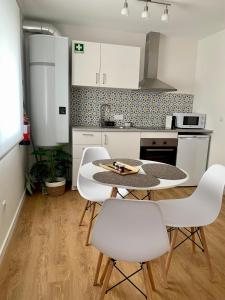 uma cozinha com uma mesa e cadeiras numa cozinha em Apartamento Sta Maria - Sta Catarina Place em Ponta Delgada