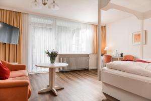 sypialnia z łóżkiem, stołem i krzesłami w obiekcie Parkhotel Weber-Müller w mieście Bad Lauterberg