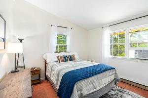a white bedroom with a bed and two windows at River Access Cabin- WiFi, Huge Deck&Grill, Hot tub in Luray