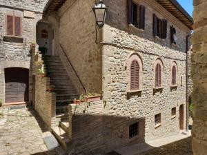 een oud stenen gebouw met een trap en een deur bij Agriturismo Giomici Bio in Valfabbrica
