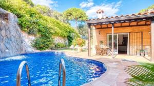 a swimming pool in a backyard with a house at Costacabana - Villa Alba in Lloret de Mar