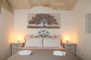 una camera da letto con un letto con due candele e un albero di La casa di Jannina a Fasano