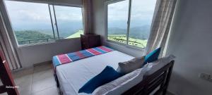 a bedroom with a bed in a room with windows at ATT's eagles nest in Kandy