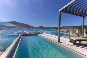 a swimming pool with a view of the water at Seafront villa with roofpool, perfect getaway in Vinišće