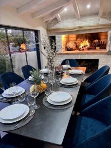a long table with plates and wine glasses and a fireplace at Seafront villa with roofpool, perfect getaway in Vinišće