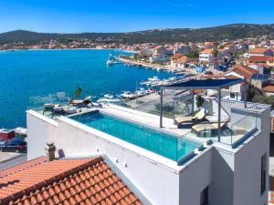 a villa with a swimming pool and a view of the water at Seafront villa with roofpool, perfect getaway in Vinišće