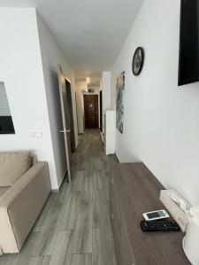 przedpokój pokoju z kanapą i zegarem w obiekcie Blue Ocean Apartment w mieście Torremolinos +11 zdjęć