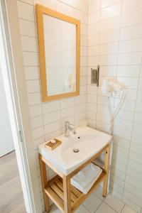 La salle de bains est pourvue d'un lavabo et d'un miroir. dans l'établissement Lijo, à Gargždai