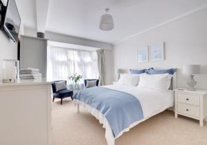 a white bedroom with a large bed and a desk at Harbour View Lynmouth in Lynmouth