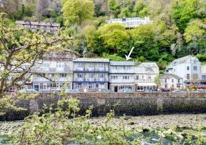 a group of houses on a hill next to the water at Harbour View Lynmouth in Lynmouth
