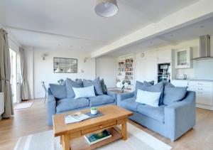 ein Wohnzimmer mit 2 blauen Sofas und einem Tisch in der Unterkunft Harbour View Lynmouth in Lynmouth