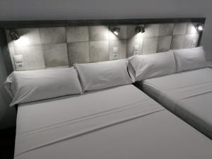 a room with two beds with white pillows at Hello Home Canillas in Madrid