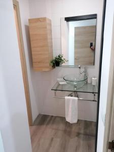 a bathroom with a glass sink and a mirror at Hello Home Canillas in Madrid