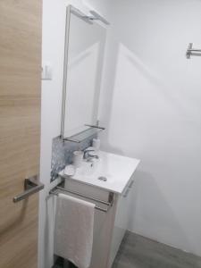 a white bathroom with a sink and a mirror at Hello Home Canillas in Madrid