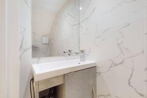 倫敦的住宿－Stunning 3 bedroom maisonette in Shepherd's Bush，白色的浴室设有水槽和镜子