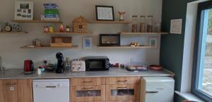 a kitchen with a counter with a microwave and a refrigerator at Cedar Lodge in Killarney