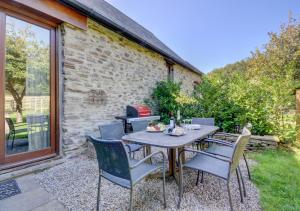 a table and chairs on a patio with a grill at Hawthorn Cottage in Barbrook