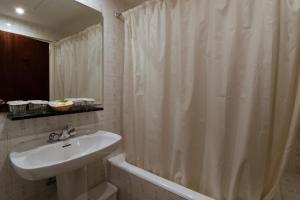 baño con lavabo y cortina de ducha en Hotel Delavall, en Vielha