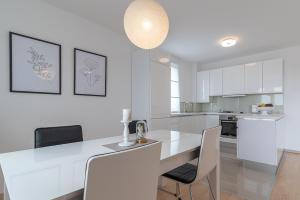 een witte keuken met een witte tafel en stoelen bij Apartman Marino in Trogir