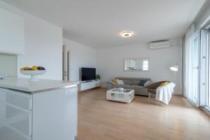 een witte woonkamer met een bank en een tafel bij Apartman Marino in Trogir
