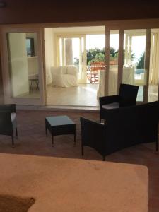 sala de estar con sofás, sillas y mesa en VILLA ASFODELO-INFINITYHOLIDAYS, en Costa Paradiso