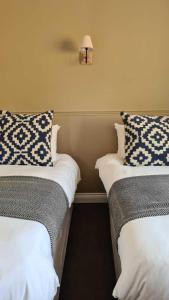 twee bedden naast elkaar in een kamer bij The Cricketers Inn in Petersfield