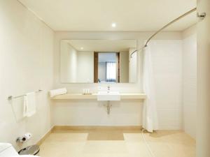 a white bathroom with a sink and a mirror at Caluce Apt 2B by Letoh in Chía
