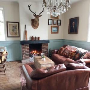 sala de estar con 2 sofás y chimenea en The Cricketers Inn, en Petersfield