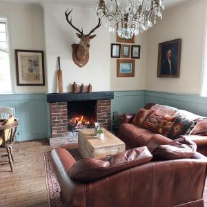 a living room with two couches and a fireplace at The Cricketers Inn in Petersfield