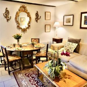 uma sala de estar com uma mesa e um sofá e uma sala de jantar em Sarlat Town House, gîte de charme em Sarlat-la-Canéda