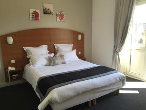 a bedroom with a large bed with a wooden headboard at Alerion Centre Gare in Metz