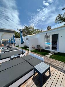 un patio con mesas y sombrillas en una terraza en Bamboo Suites Hotel en Ialyssos