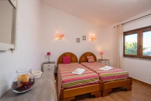 a bedroom with two beds and a table at Vivenda Solar dos Pescadores in Armação de Pêra +41 photos