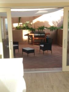 un patio cubierto con mesa y sillas en VILLA ASFODELO-INFINITYHOLIDAYS, en Costa Paradiso