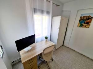 a office with a desk with a computer and a refrigerator at Comfy Apartment With a Castle View in Cullera