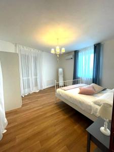 1 dormitorio con 1 cama grande y suelo de madera en Maison Bon Ton, en Villafranca dʼAsti
