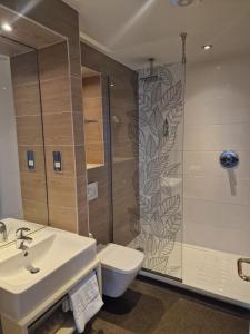 uma casa de banho com um chuveiro, um lavatório e um WC. em The Queen Hotel Wetherspoon em Aldershot