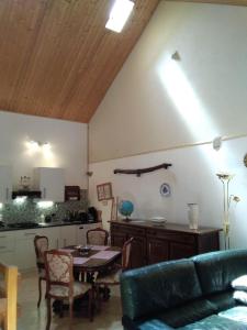 sala de estar con sofá, mesa y cocina en Hirondelles et mésanges, en Fromental