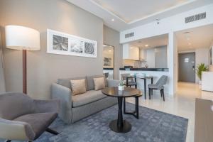 een woonkamer met een bank en een tafel bij Spectacular Burj Khalifa view service apartment in Dubai